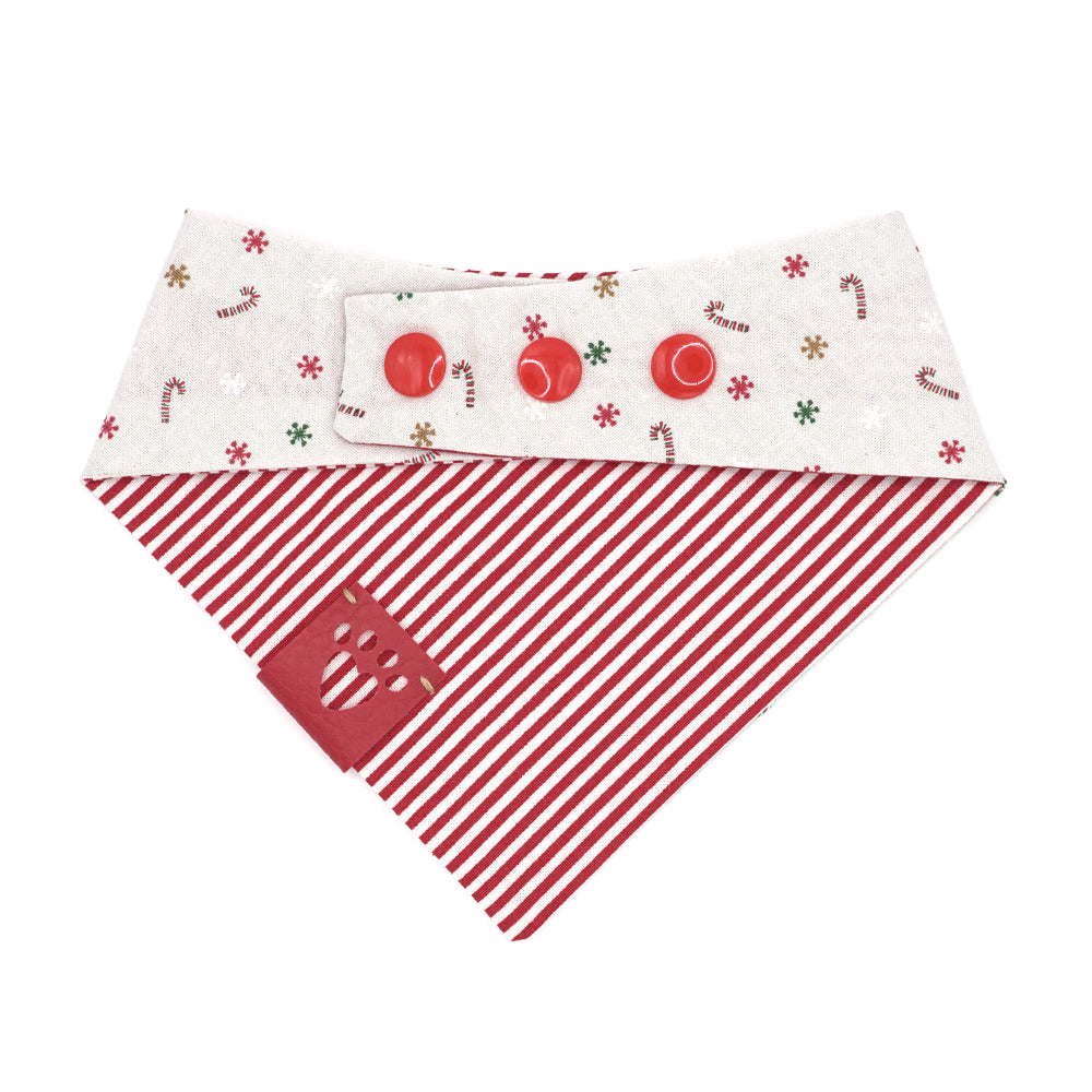 Reversible bandana for dogs. Snaps on back make it adjustable. One side is Light grey (almost white) background with red/white candy canes, and red, green, gold and white snowflakes and the other side has Red and white stripes. Red tag with heart paw cut out on side.