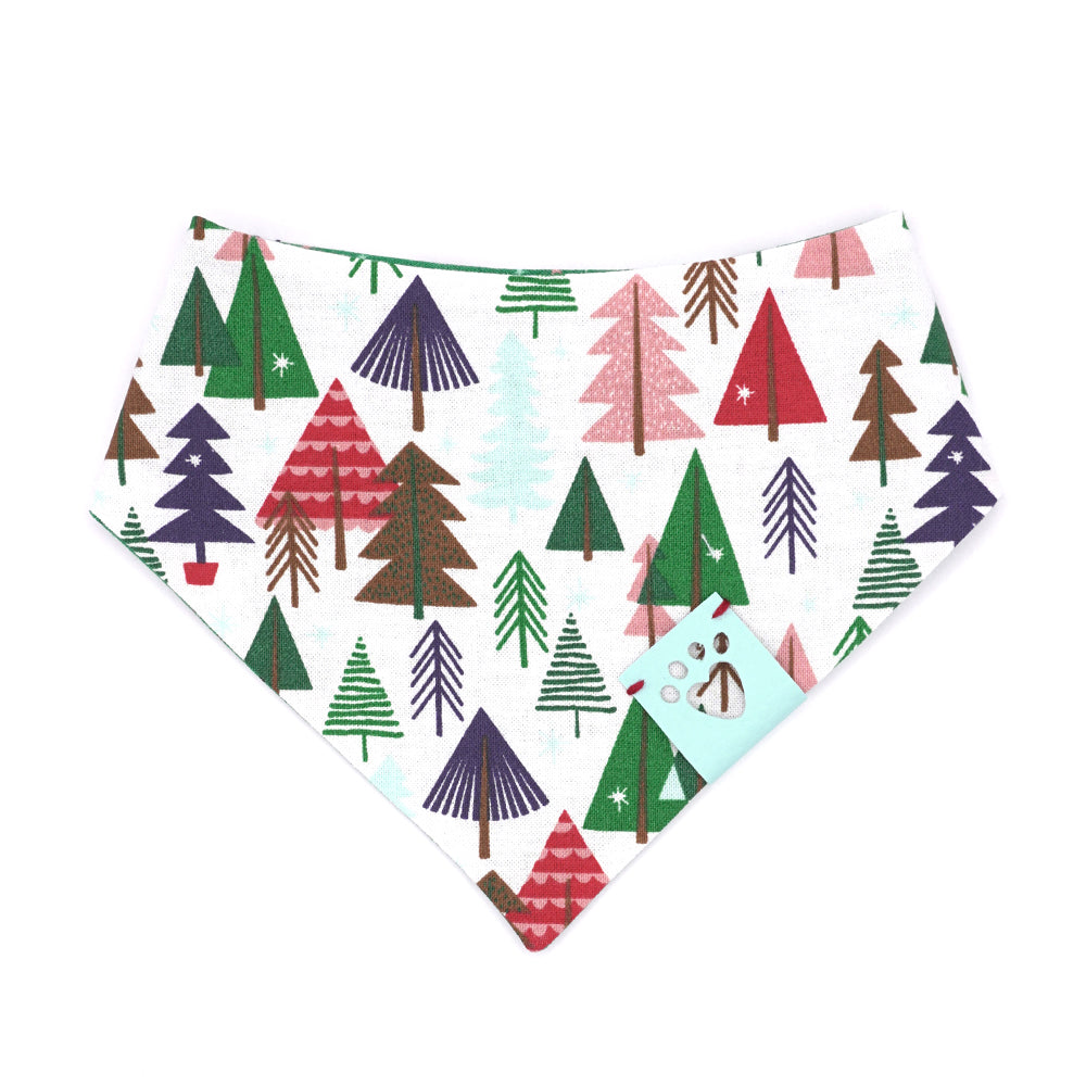 Reversible bandana for dogs. Snaps on back make it adjustable. One side is White background with illustrated trees in red, green, light blue, navy blue and brown and the other side has a Kelly green background with white, red, pink, light blue, dark green and navy blue stars. Light blue tag with heart paw cut out on side.