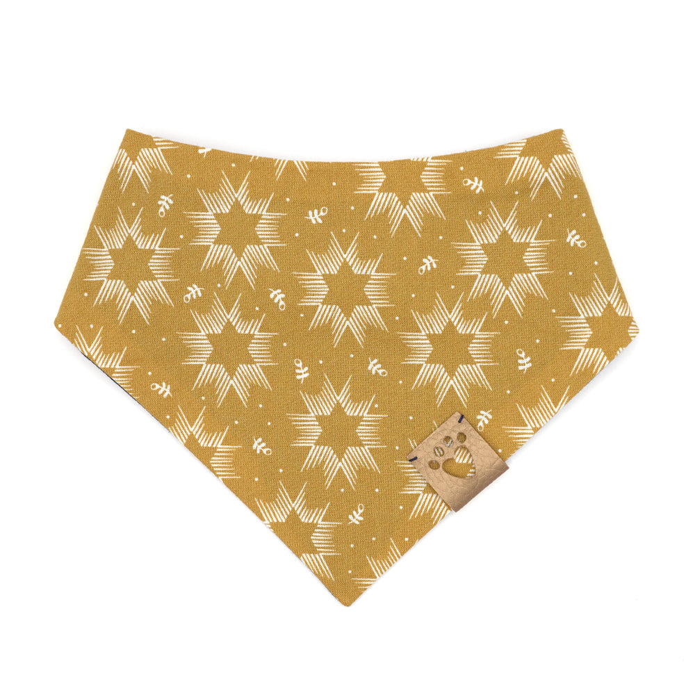 Reversible bandana for dogs. Snaps on back make it adjustable. One side is Mustard yellow background with cream Stars of David and the other side has a Navy blue background with white and yellow "splatter" dots. Metallic gold tag with heart paw cut out on side.