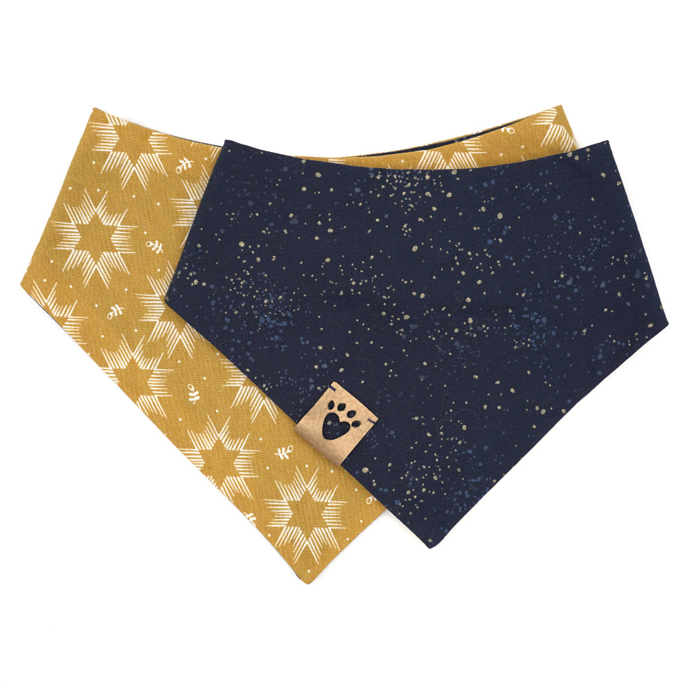 Reversible bandana for dogs. Snaps on back make it adjustable. One side is Mustard yellow background with cream Stars of David and the other side has a Navy blue background with white and yellow "splatter" dots. Metallic gold tag with heart paw cut out on side.