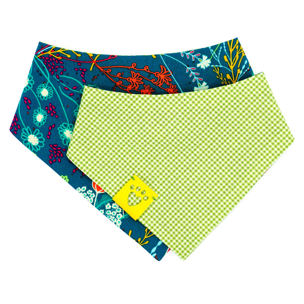 Reversible bandana for dogs. Snaps on back make it adjustable. One side is Dark green/teal background with magenta, dark purple, lime green, white, light blue, goldenrod, and orange flowers and the other side has a Bright lime green and white gingham pattern. Yellow tag with heart paw cut out on side.