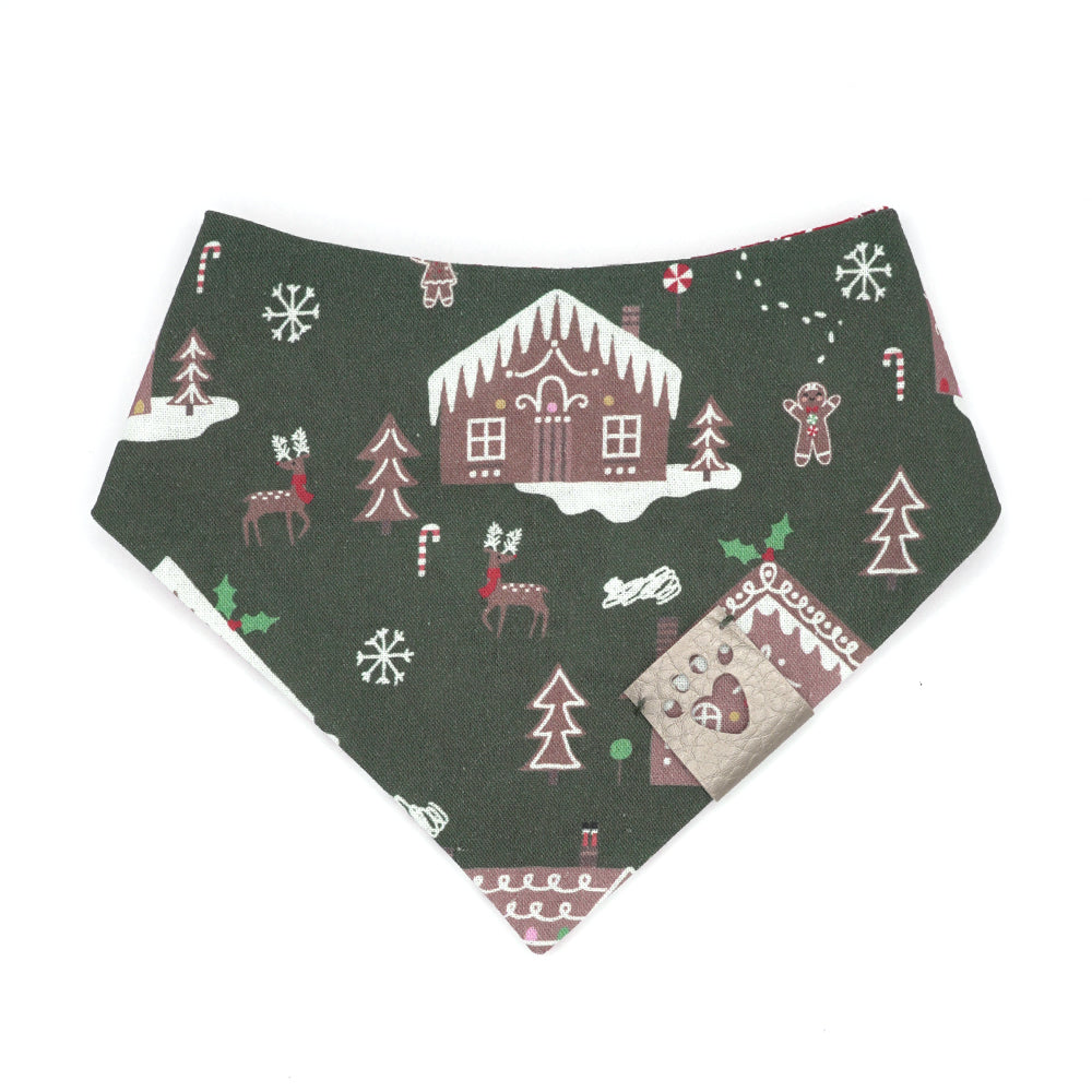 Reversible bandana for dogs. Snaps on back make it adjustable. One side is Dark green background with brown gingerbread houses/people, white icing, snowflakes, and multi-colored candies and decorations and the other side has a White background with dark red, red and white peppermint swirl candies. Metallic Silver tag with heart paw cut out on side.