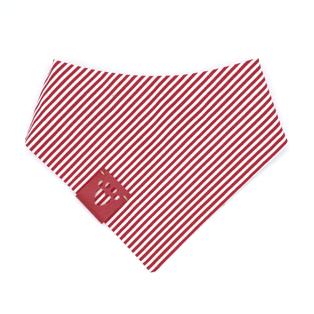 Reversible bandana for dogs. Snaps on back make it adjustable. One side is Light grey (almost white) background with red/white candy canes, and red, green, gold and white snowflakes and the other side has Red and white stripes. Red tag with heart paw cut out on side.