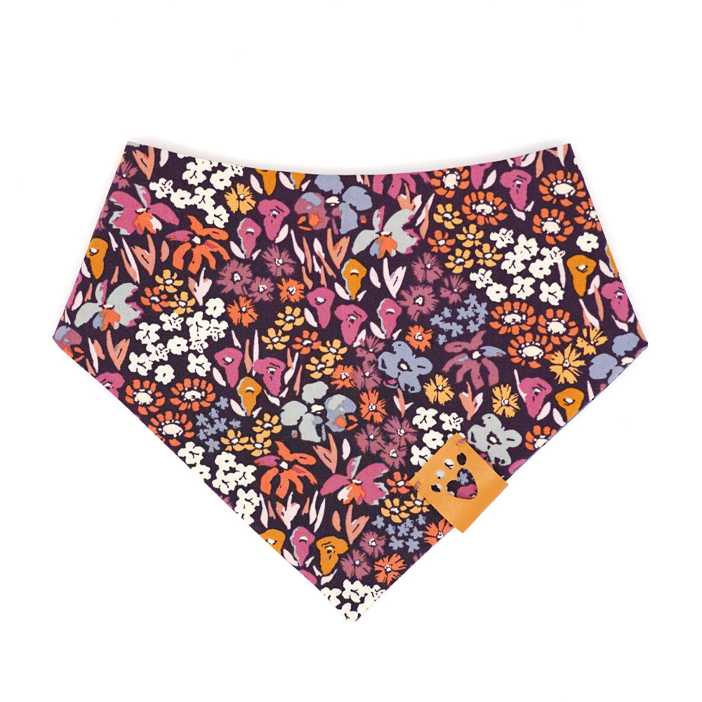Reversible bandana for dogs. Snaps on back make it adjustable. One side is Periwinkle blue background with mini black and white pandas and the other side has a Dark purple background with coral, pink, cream, gold, orange and periwinkle flowers. Tan tag with heart paw cut out on side.