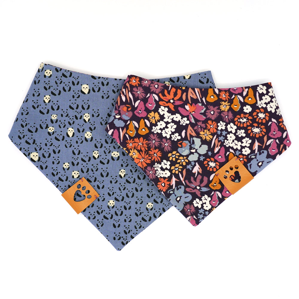 Reversible bandana for dogs. Snaps on back make it adjustable. One side is Periwinkle blue background with mini black and white pandas and the other side has a Dark purple background with coral, pink, cream, gold, orange and periwinkle flowers. Tan tag with heart paw cut out on side.