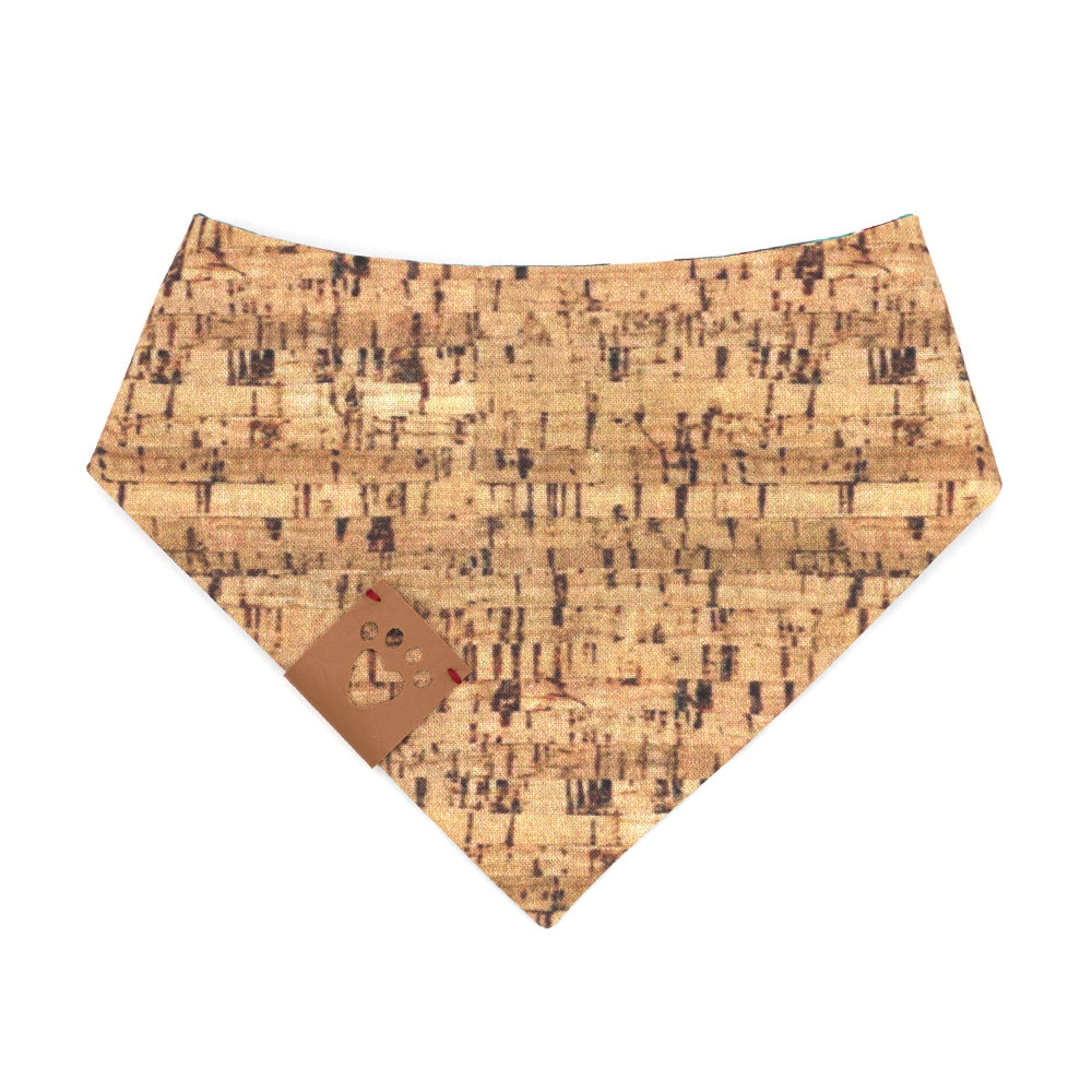 Reversible bandana for dogs. Snaps on back make it adjustable. One side is Turquoise background with red wine bottles and glasses and the other side has a Tan/brown cork pattern. Tan tag with heart paw cut out on side.