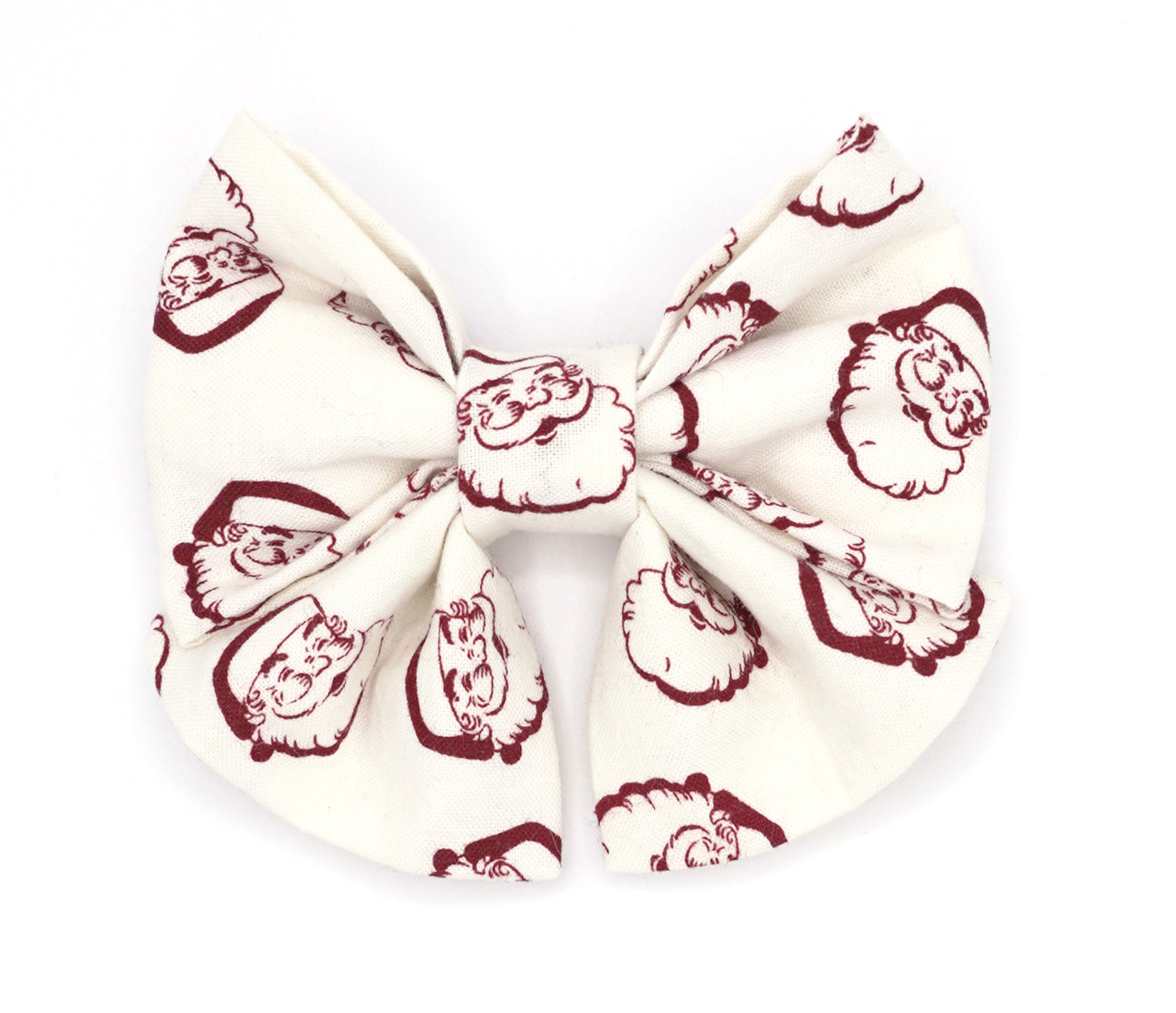 Handmade cotton bow tie with tails for dogs (or other pets). Elastic straps on back with snaps make it easy to add to collar, harness, or leash. White background with dark red vintage Santa heads.