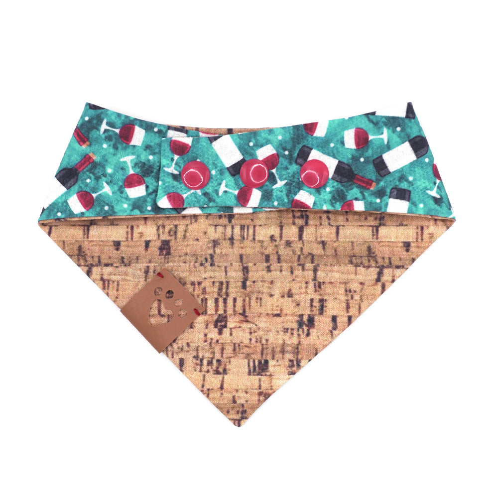 Reversible bandana for dogs. Snaps on back make it adjustable. One side is Turquoise background with red wine bottles and glasses and the other side has a Tan/brown cork pattern. Tan tag with heart paw cut out on side.