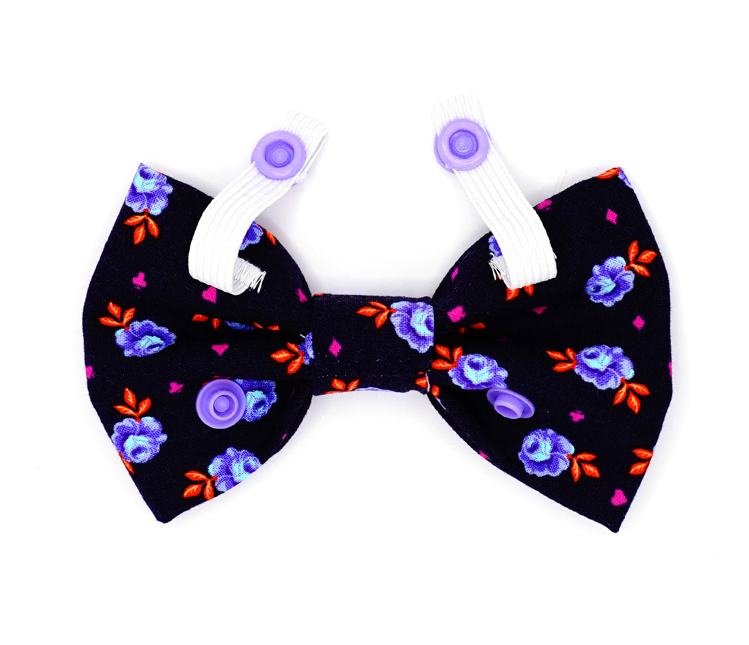 Handmade cotton bow tie for dogs (or other pets). Elastic straps on back with snaps make it easy to add to collar, harness, or leash. Navy blue background with purple and light blue rose buds, bright orange leaves and bright purple accent shapes.