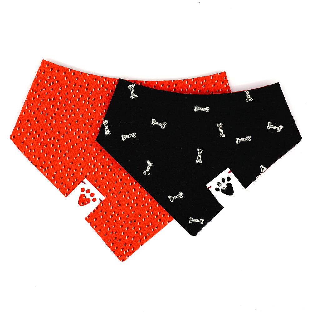Reversible bandana for dogs. Snaps on back make it adjustable. One side is Black background with white illustrated dog bones and the other side has a Red/orange background with black and white strawberry seeds pattern. White tag with heart paw cut out on side.