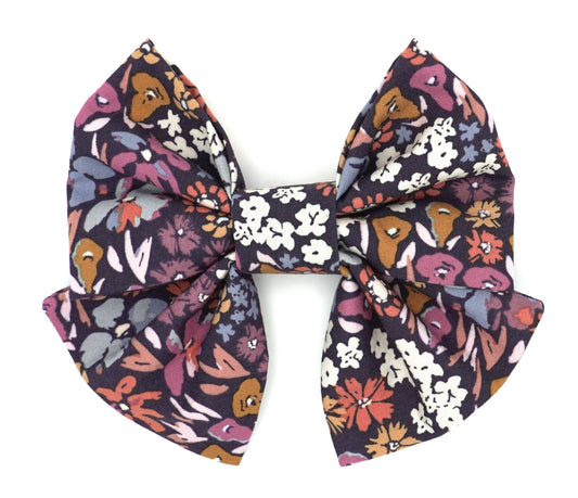 Handmade cotton bow tie with tails for dogs (or other pets). Elastic straps on back with snaps make it easy to add to collar, harness, or leash. Dark purple background with coral, pink, cream, gold, orange and periwinkle flowers