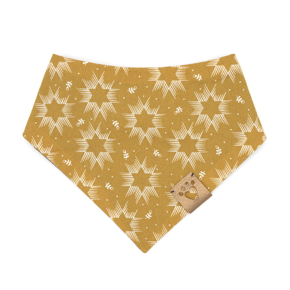 Reversible bandana for dogs. Snaps on back make it adjustable. One side is Mustard yellow background with cream Stars of David and the other side has a Navy blue background with white and yellow "splatter" dots. Metallic gold tag with heart paw cut out on side.