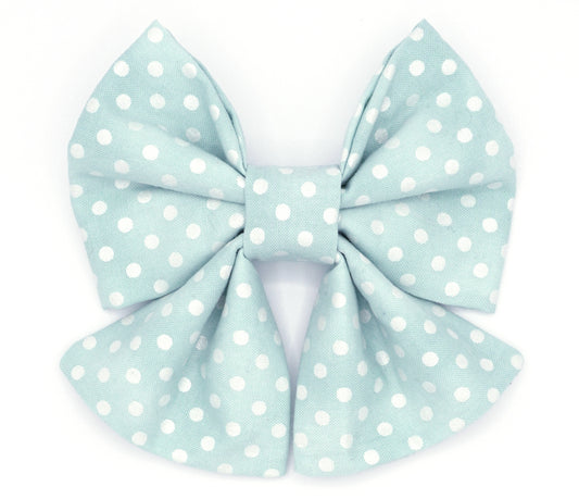 Handmade cotton bow tie with tails for dogs (or other pets). Elastic straps on back with snaps make it easy to add to collar, harness, or leash. Distressed minty blue background with white polka dots.