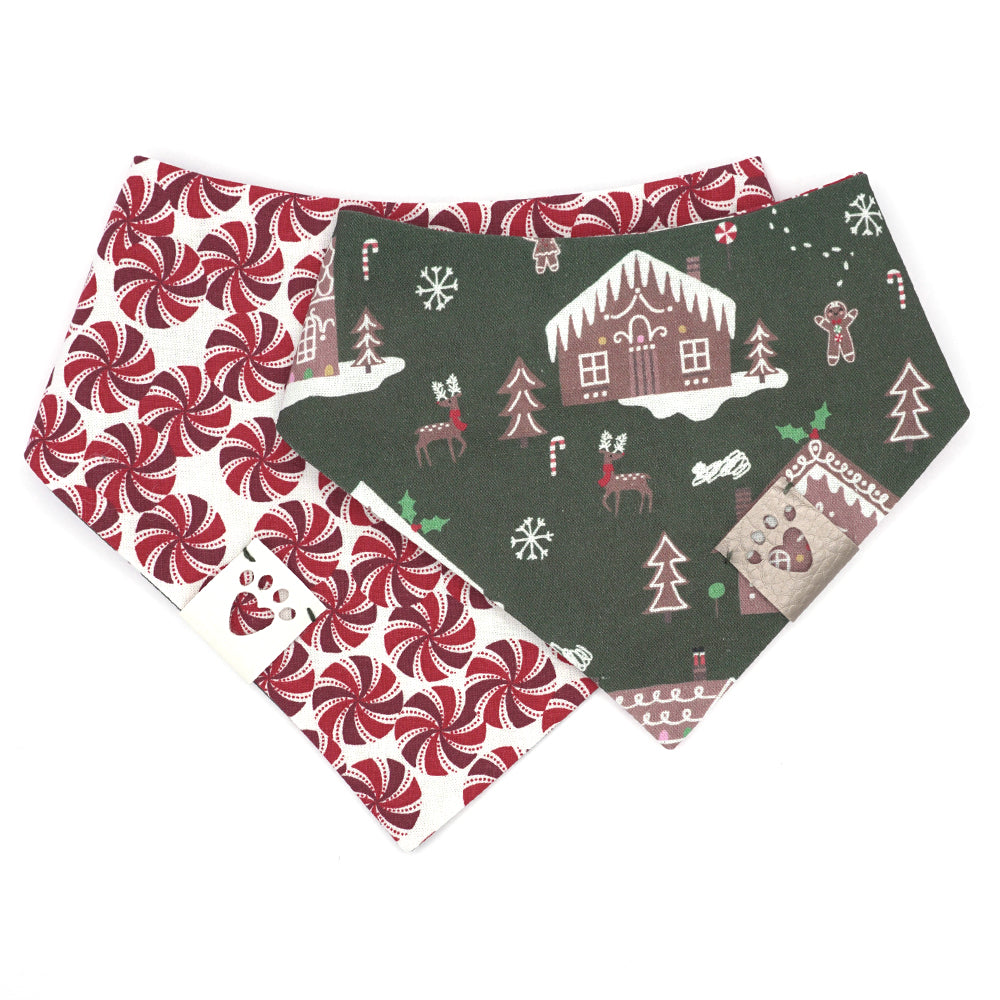 Reversible bandana for dogs. Snaps on back make it adjustable. One side is Dark green background with brown gingerbread houses/people, white icing, snowflakes, and multi-colored candies and decorations and the other side has a White background with dark red, red and white peppermint swirl candies. Metallic Silver tag with heart paw cut out on side.