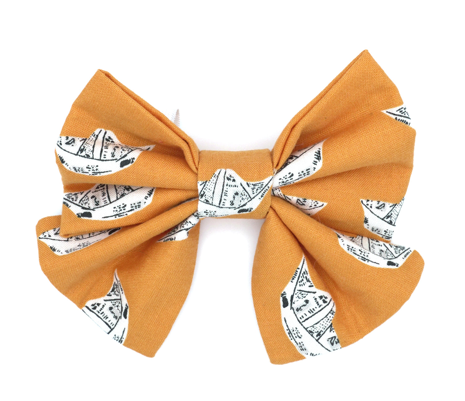 Handmade cotton bow tie with tails for dogs (or other pets). Elastic straps on back with snaps make it easy to add to collar, harness, or leash. Bright orange background with newsprint boats.