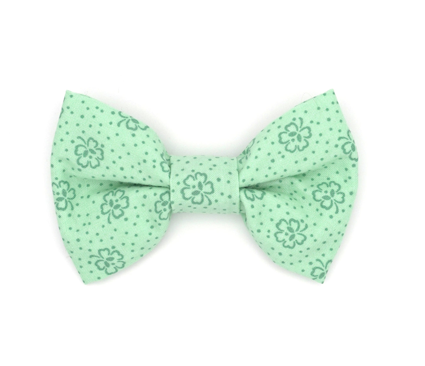 Handmade cotton bow tie for dogs (or other pets). Elastic straps on back with snaps make it easy to add to collar, harness, or leash. Light Green background with dark green four leaf clovers.