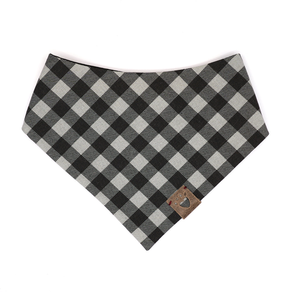 Reversible bandana for dogs. Snaps on back make it adjustable. One side is Black and grey buffalo plaid and the other side has a Black background with dark grey polk-a-dots. Warm Grey tag with heart paw cut out on side.