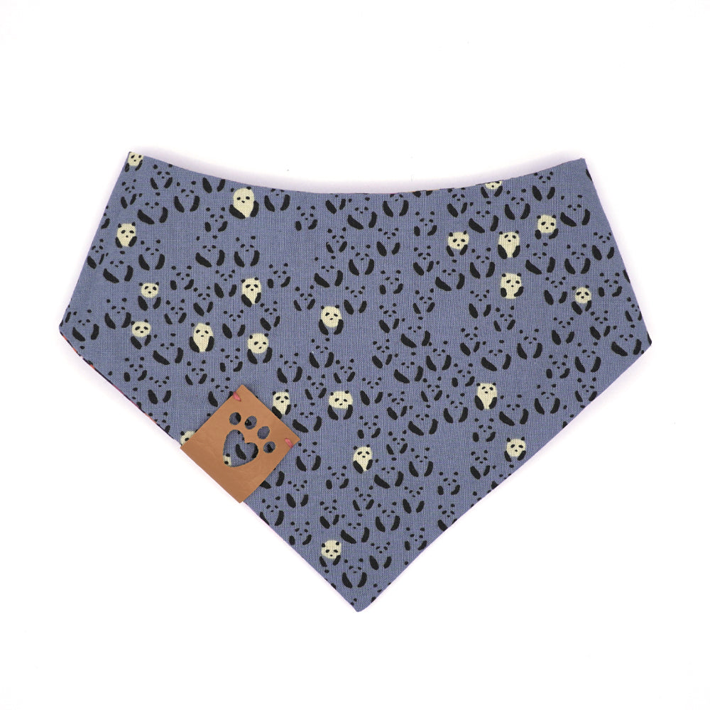 Reversible bandana for dogs. Snaps on back make it adjustable. One side is Periwinkle blue background with mini black and white  pandas and the other side has a Dark purple background with coral, pink, cream, gold, orange and periwinkle flowers. Tan tag with heart paw cut out on side.