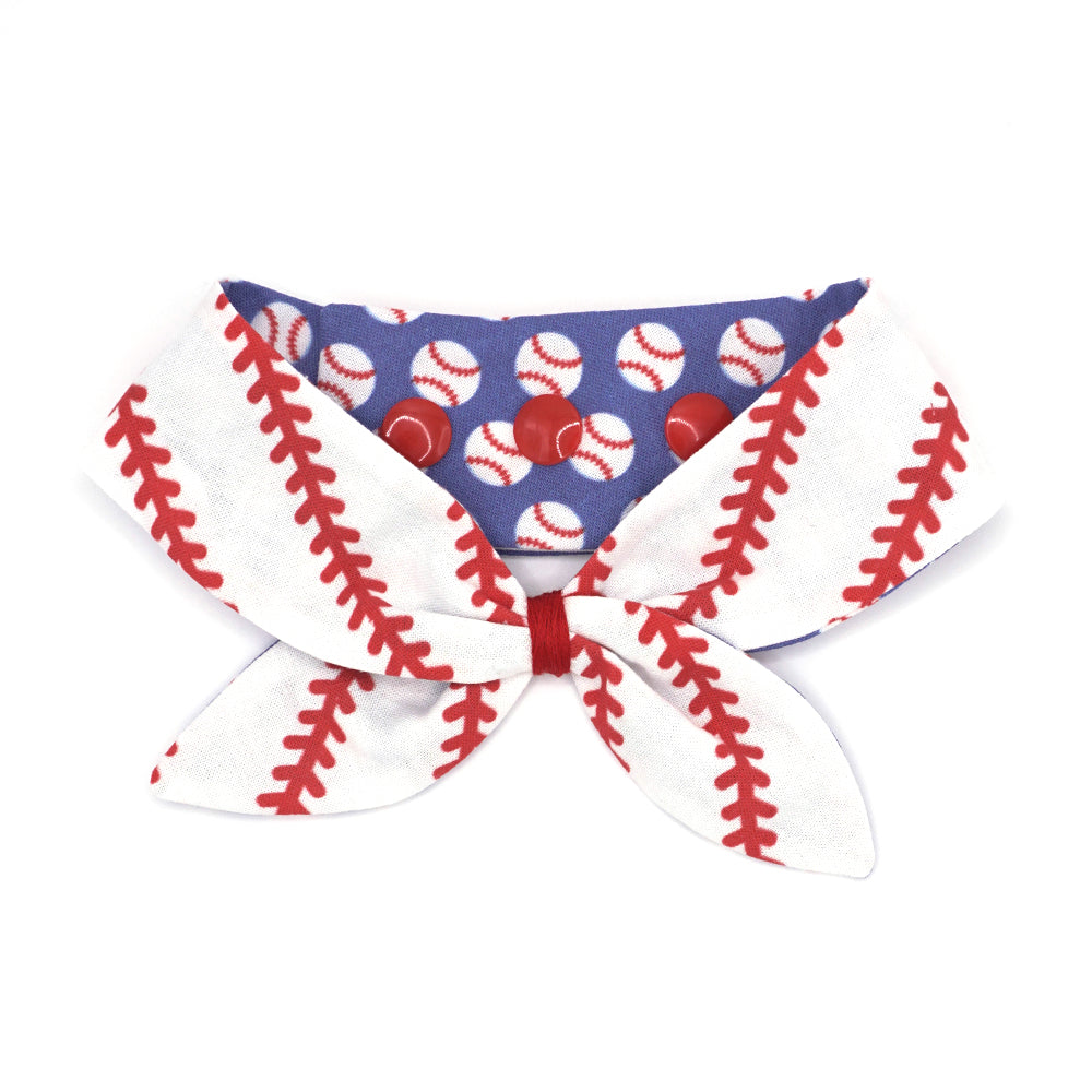 Reversible neckerchief for dogs. Snaps on back make it adjustable. One side White background with bright red baseball stitches and the other side has a Bright blue background with white baseballs with red stitches. Embroidery thread wrapped center in red.