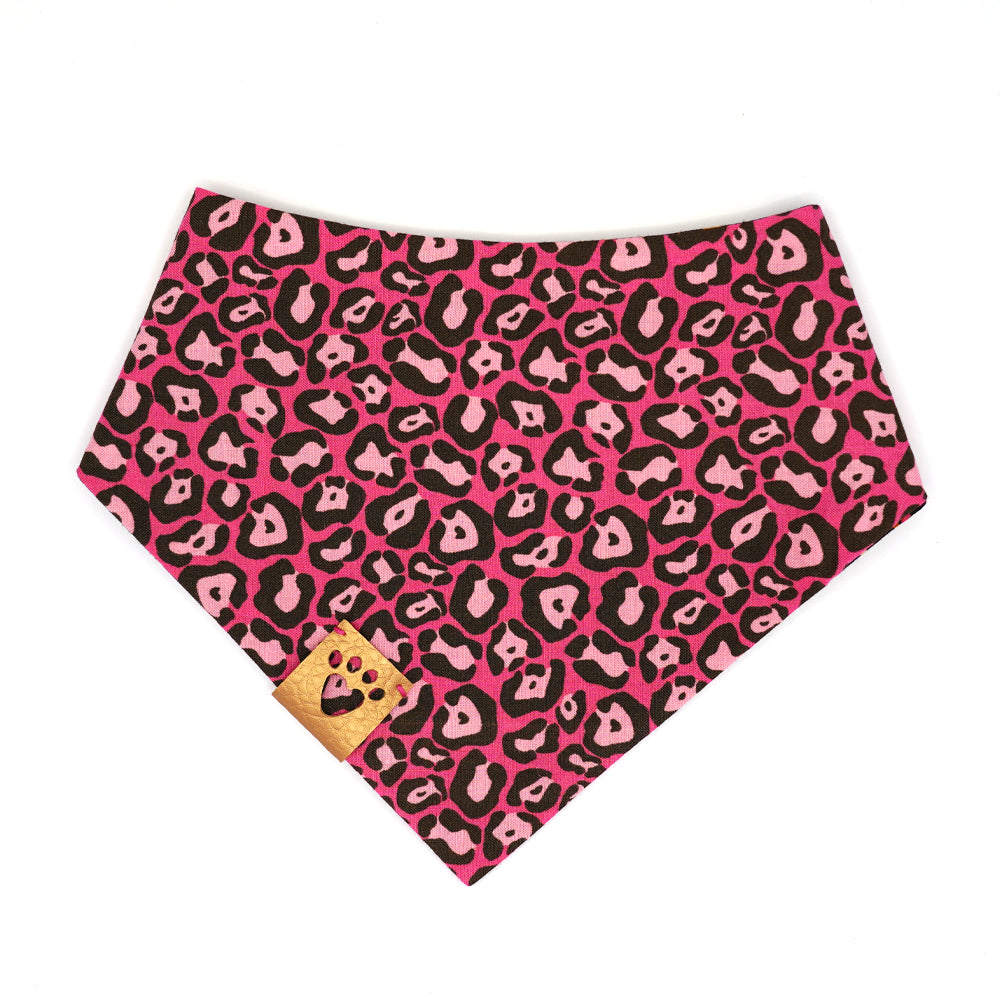 Reversible bandana for dogs. Snaps on back make it adjustable. One side is Hot pink background with light pink and charcoal grey leopard print and the other side has a Black background with hot pink, amber, gold and cream flowers. Metallic gold tag with heart paw cut out on side.