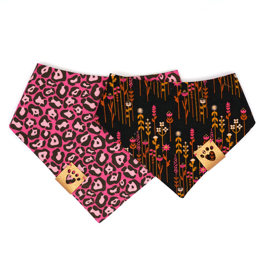 Reversible bandana for dogs. Snaps on back make it adjustable. One side is Hot pink background with light pink and charcoal grey leopard print and the other side has a Black background with hot pink, amber, gold and cream flowers. Metallic gold tag with heart paw cut out on side.