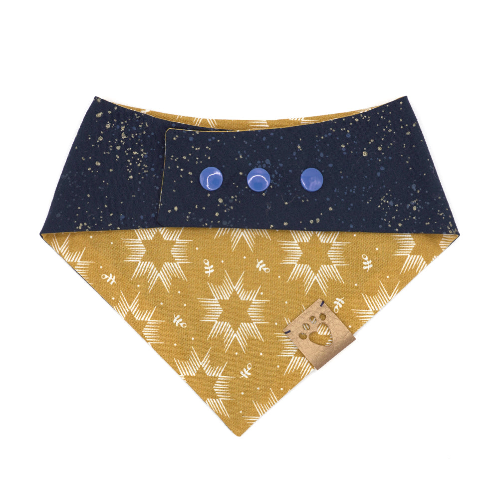 Reversible bandana for dogs. Snaps on back make it adjustable. One side is Mustard yellow background with cream Stars of David and the other side has a Navy blue background with white and yellow "splatter" dots. Metallic gold tag with heart paw cut out on side.