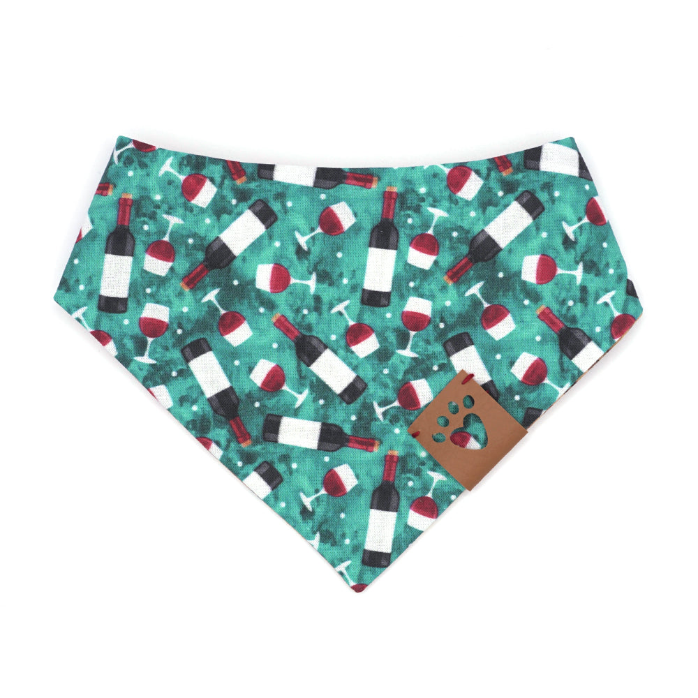 Reversible bandana for dogs. Snaps on back make it adjustable. One side is Turquoise background with red wine bottles and glasses and the other side has a Tan/brown cork pattern. Tan tag with heart paw cut out on side.