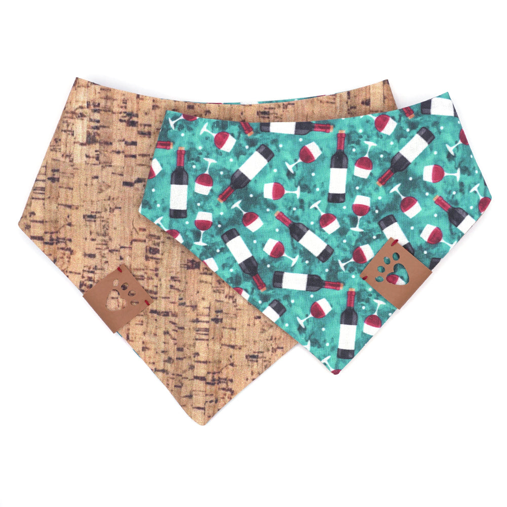 Reversible bandana for dogs. Snaps on back make it adjustable. One side is Turquoise background with red wine bottles and glasses and the other side has a Tan/brown cork pattern. Tan tag with heart paw cut out on side.