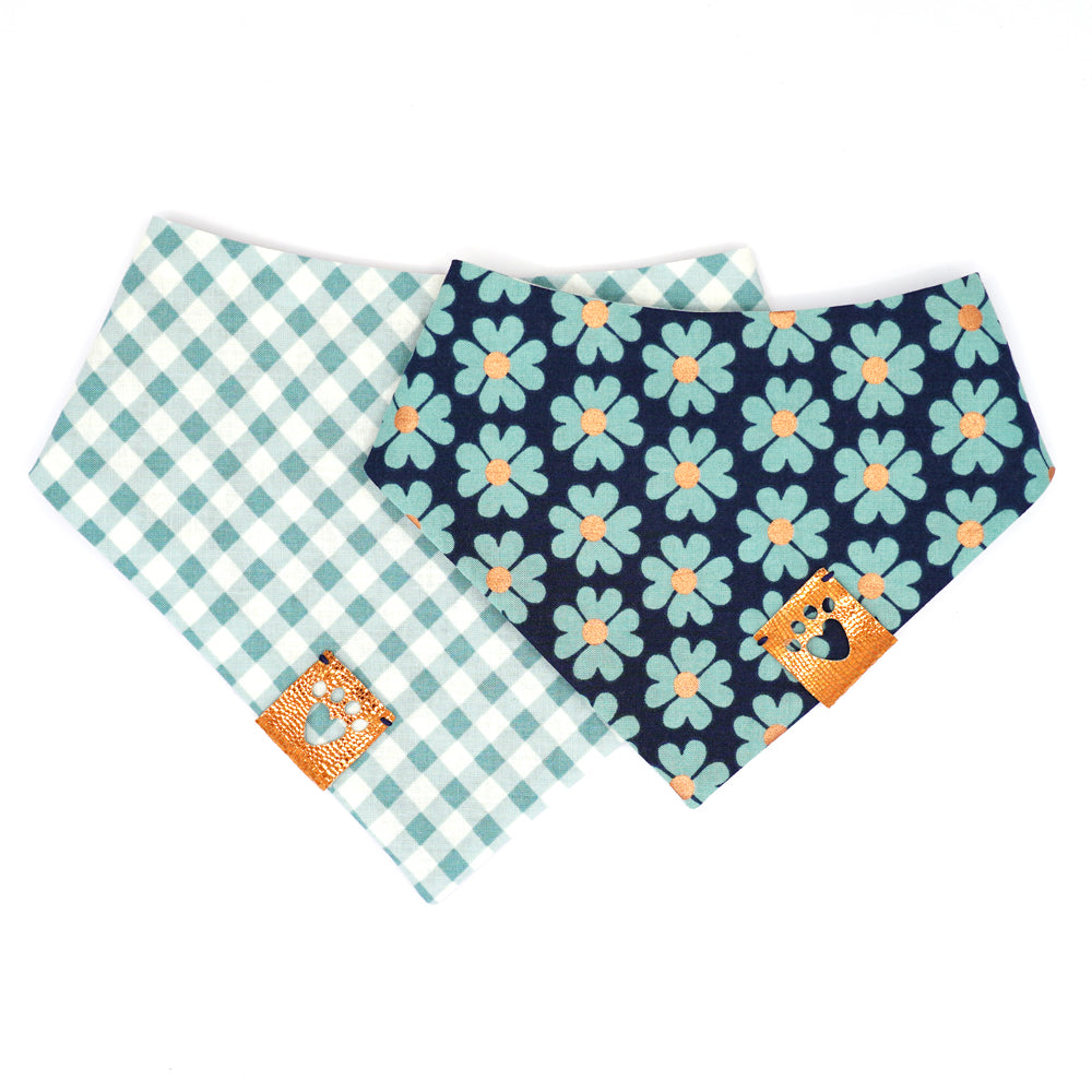Reversible bandana for dogs. Snaps on back make it adjustable. One side is White and green/blue gingham stripes and the other side has a Navy background with green/blue flowers that have metallic copper centers. Metallic copper tag with heart paw cut out on side.