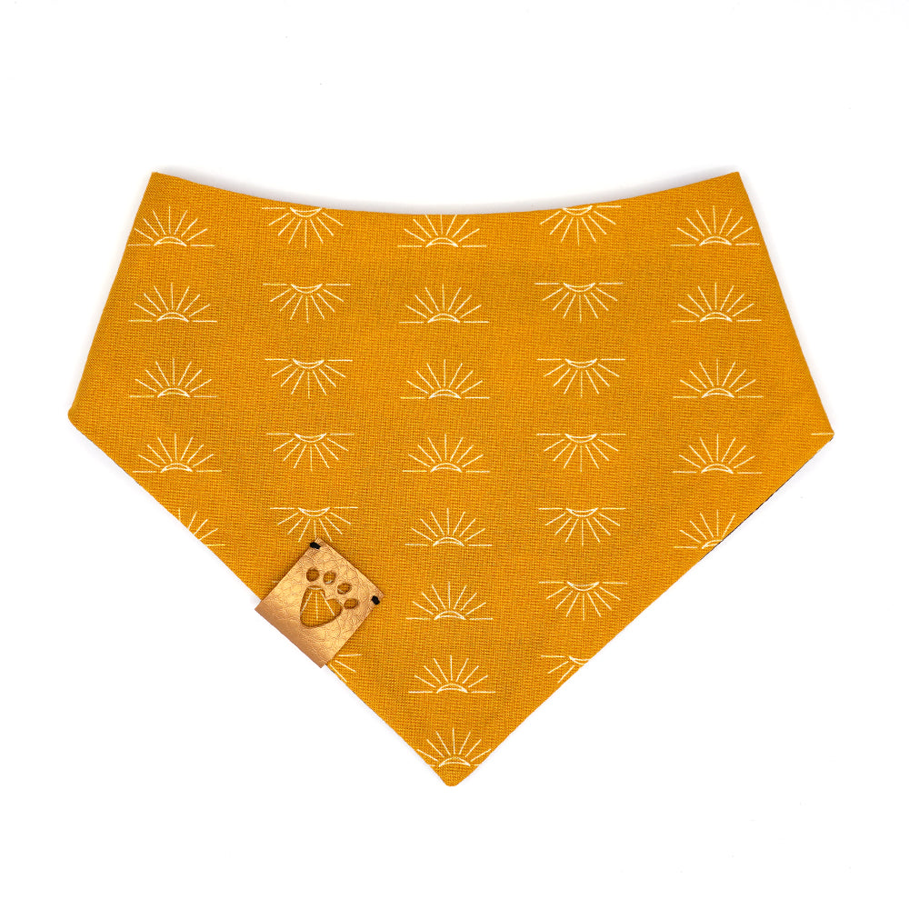 Reversible bandana for dogs. Snaps on back make it adjustable. One side is Black background with gold and yellow suns with light pink cheeks and the other side has a Red and white gingham. Metallic gold tag with heart paw cut out on side.
