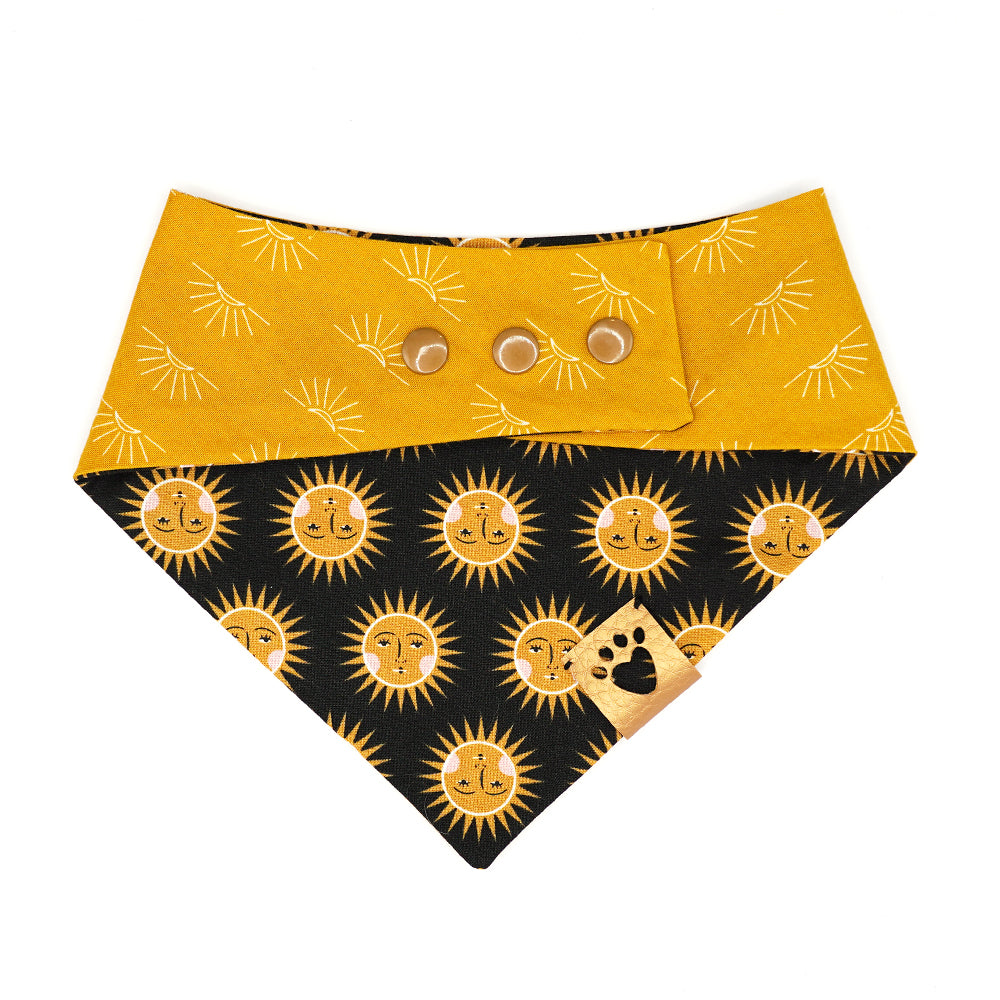 Reversible bandana for dogs. Snaps on back make it adjustable. One side is Black background with gold and yellow suns with light pink cheeks and the other side has a Red and white gingham. Metallic gold tag with heart paw cut out on side.