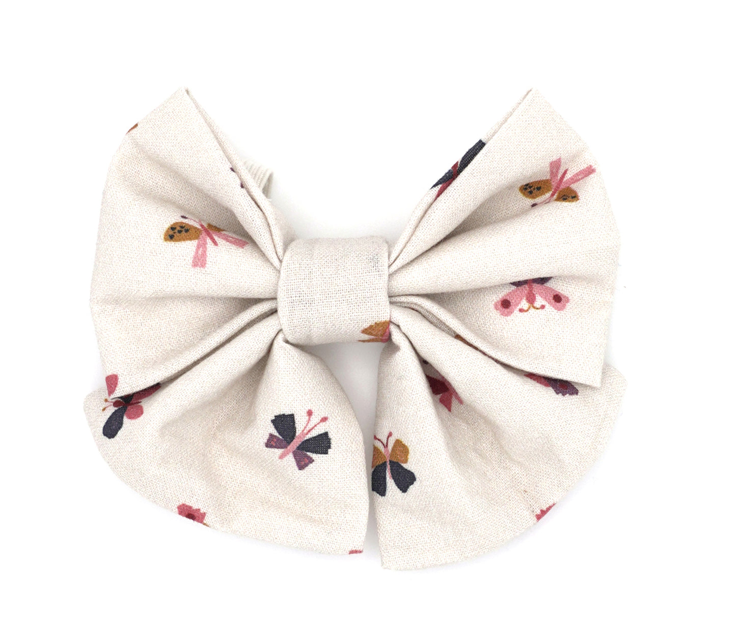 Handmade cotton bow tie with tails for dogs (or other pets). Elastic straps on back with snaps make it easy to add to collar, harness, or leash. Cream background with geometric shaped butterflies in light pink, gold, maroon, purple and navy.
