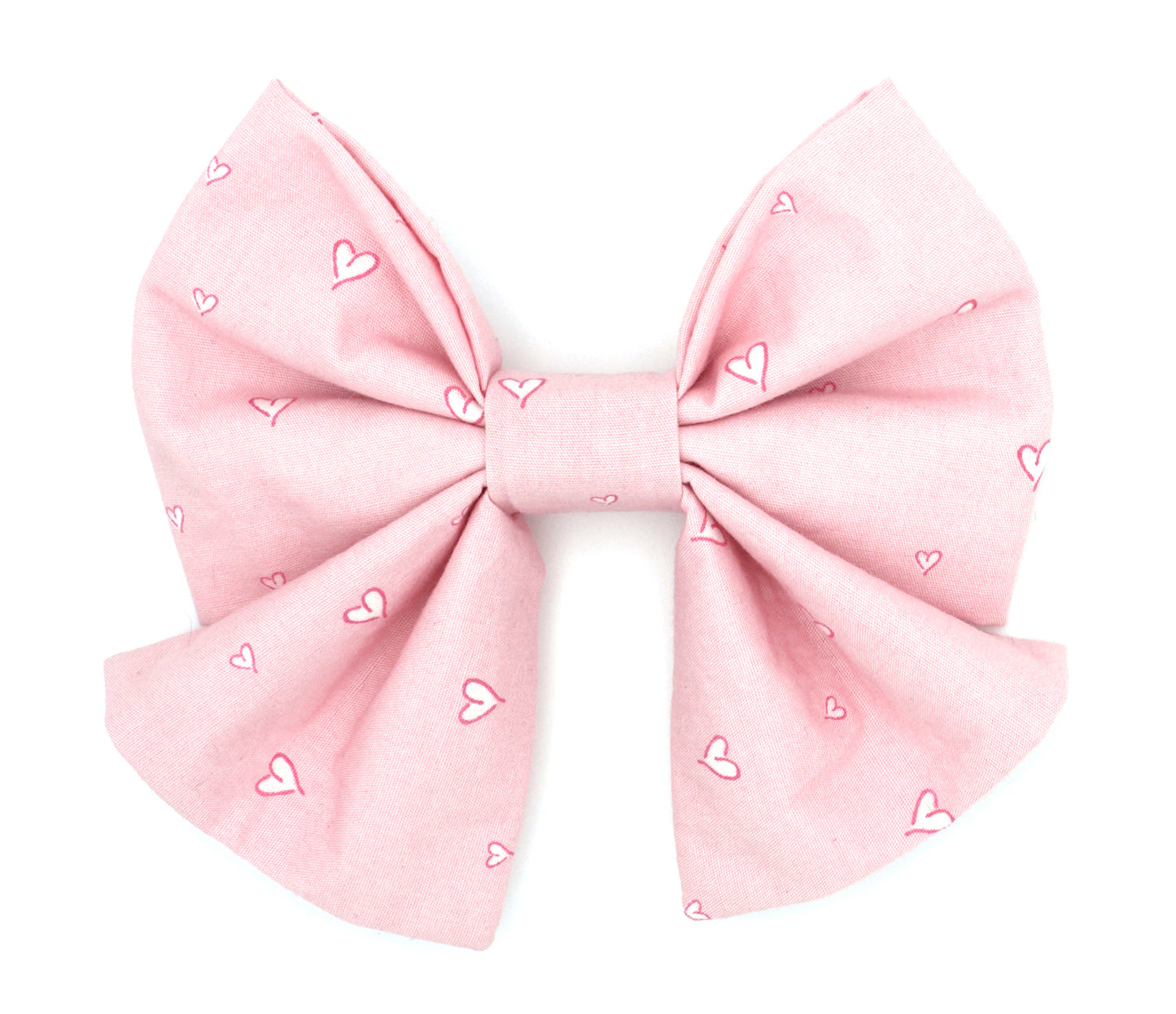 Handmade cotton bow tie with tails for dogs (or other pets). Elastic straps on back with snaps make it easy to add to collar, harness, or leash. Light pink background with hot pink and white hearts.