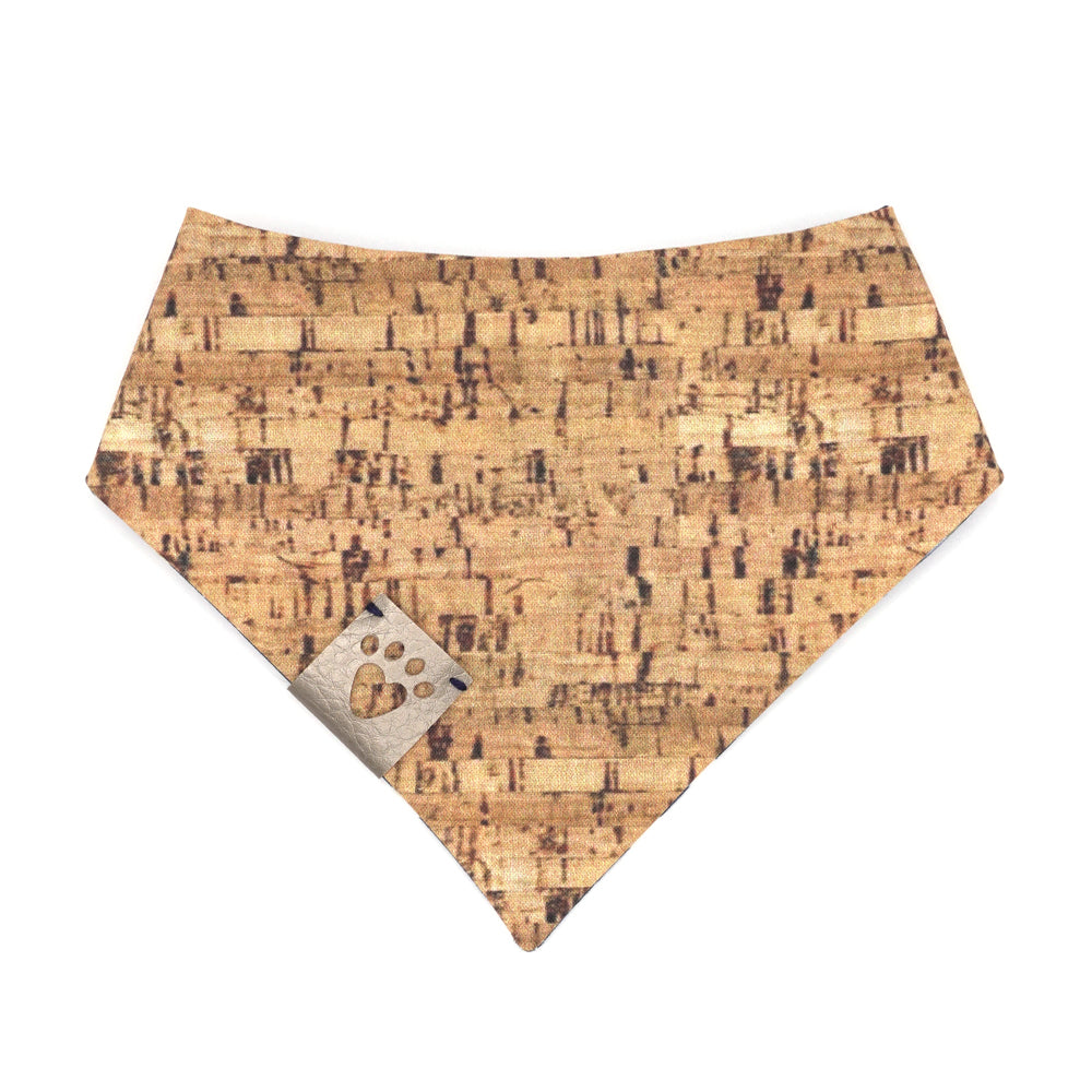 Reversible bandana for dogs. Snaps on back make it adjustable. One side is Navy blue background with white wine bottles and glasses and the other side has a Tan/brown cork pattern. Metallic Silver tag with heart paw cut out on side.