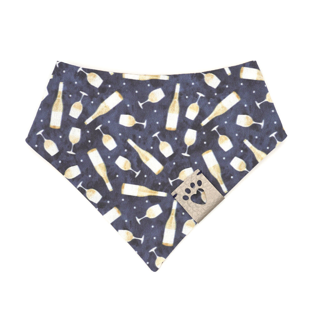 Reversible bandana for dogs. Snaps on back make it adjustable. One side is Navy blue background with white wine bottles and glasses and the other side has a Tan/brown cork pattern. Metallic Silver tag with heart paw cut out on side.