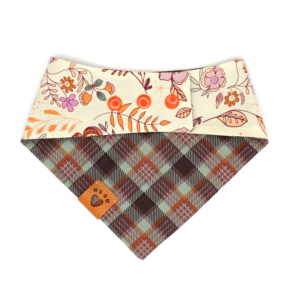 Reversible bandana for dogs. Snaps on back make it adjustable. One side is Beige background with two bunnies, the sun, butterflies and florals in goldenrod, purple, lilac, orange, seafoam green and peach and the other side has a Purple, lavender, orange, peach and seafoam green plaid. Tan tag with heart paw cut out on side.