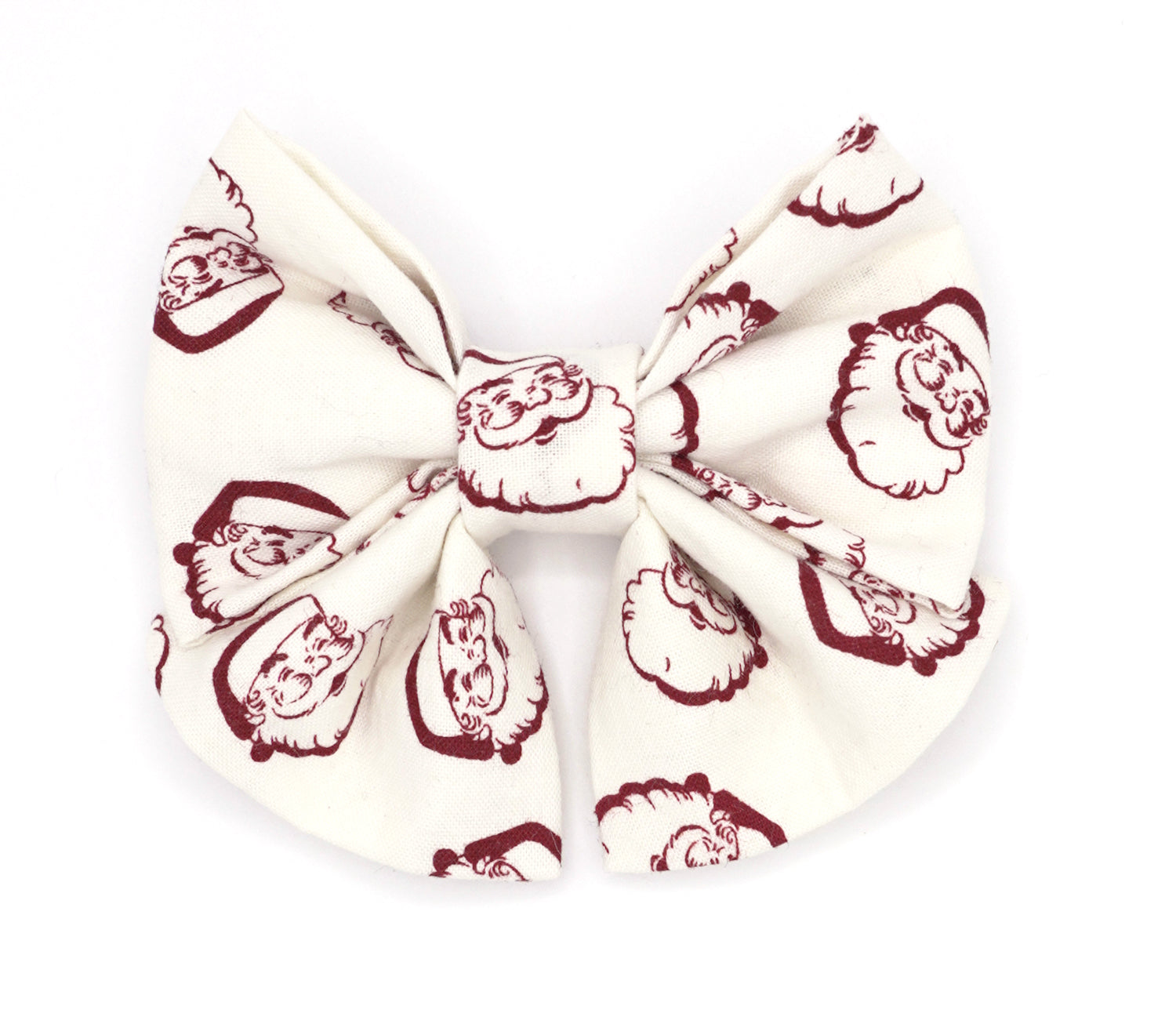 Handmade cotton bow tie with tails for dogs (or other pets). Elastic straps on back with snaps make it easy to add to collar, harness, or leash. White background with dark red vintage Santa heads.